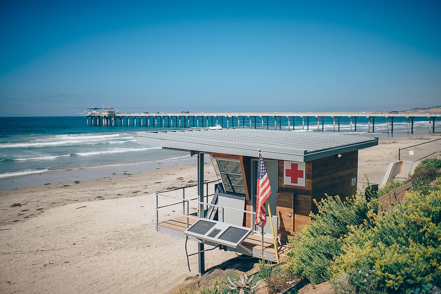 lifeguard tower, green, grass, brown, gray, house, near, ocean, blue, sky