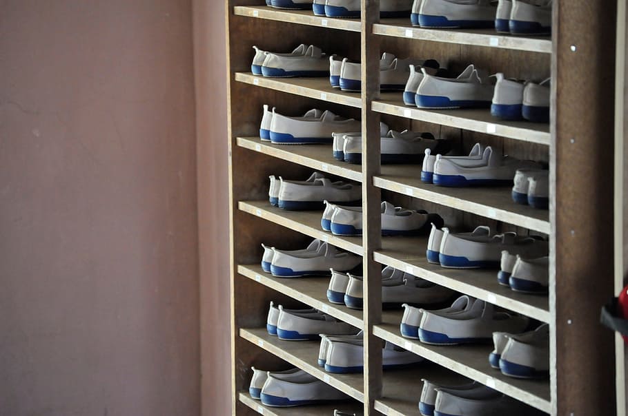 shoe, footwear, rack, furniture, pair, wall, shelf, indoors, in a row, large group of objects