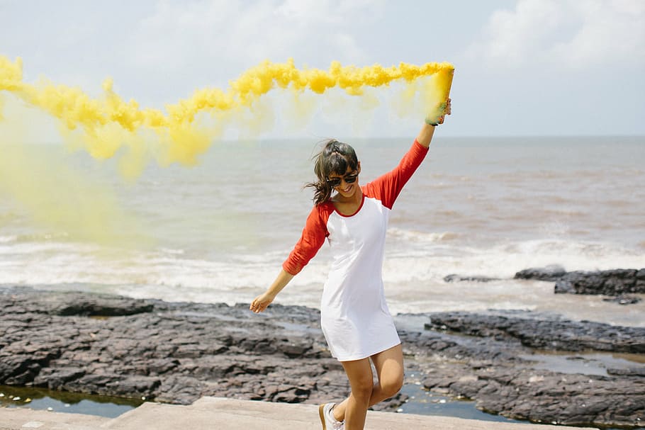 mujer rociando, amarillo, humo, aire, playa, durante el día, personas, mujer, feliz, diversión