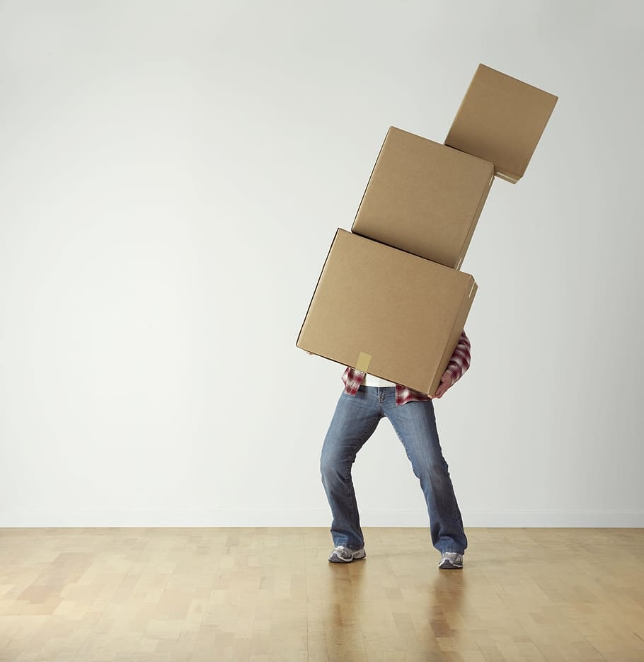 person, wearing, red, shirt, carrying, three, brown, boxes, cardboard, overload