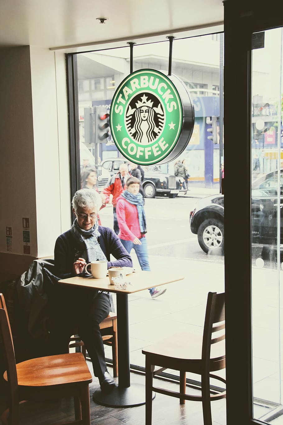 mujer, sentado, silla, al lado, pared de vidrio, Londres, Starbucks, Starbucks Coffee, tienda, escena