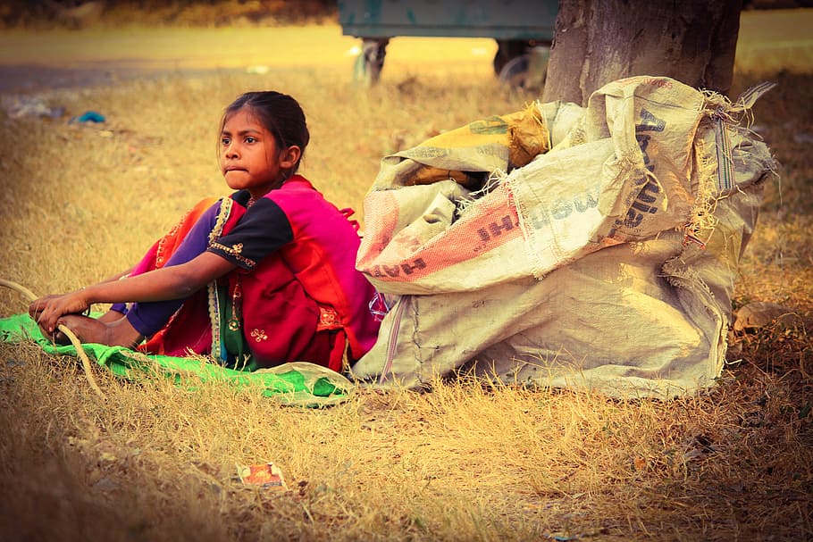 girl, wearing, pink, black, sleeved dress, sitting, ground, poverty, hungry, sadness
