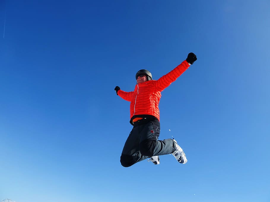 person, red, bubble jacket, jumping, daytime, skiing, jump, sky, blue, motion