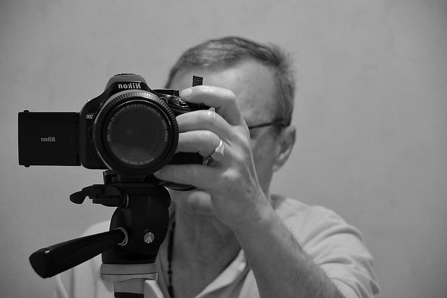 fotografía en escala de grises, hombre, sosteniendo, cámara Nikon DSLR, imagen, ajuste, objetivo, zoom, blanco y negro, fotógrafo