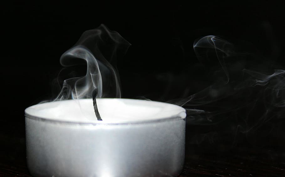 grayscale photography, candle, tealight, blown out, smoke, wick, smoke - physical structure, black background, studio shot, food and drink