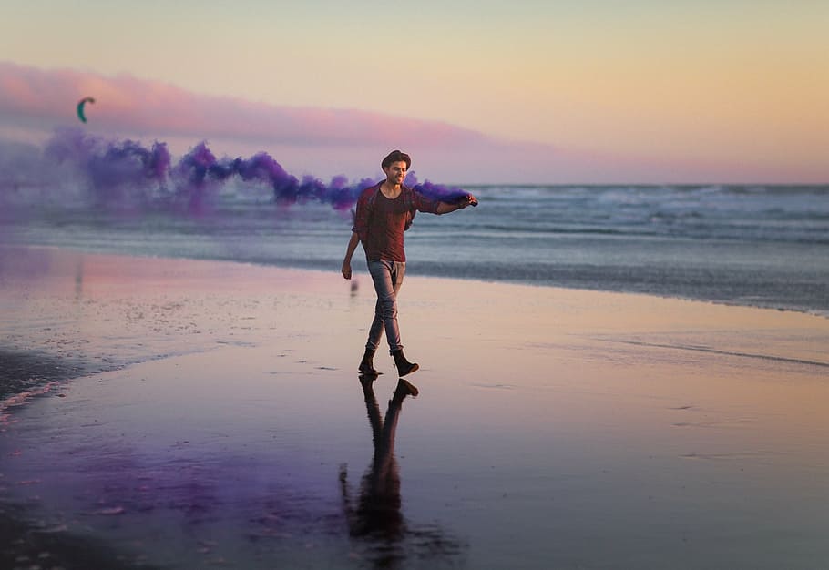 man, walking, seashore, holding, smoke machine, daytime, sea, ocean, water, beach