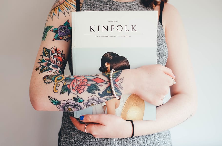 mulher, cinza, de malha, vestido, segurando, livro kinfolk, Kinfolk, livro, tatuagens, tatuagens de flores