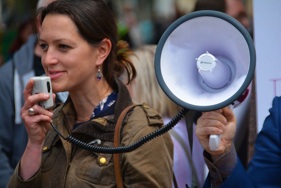 woman, brown, jacket, holding, megaphone, daytime, loud speaker, speaker, voice, announcement