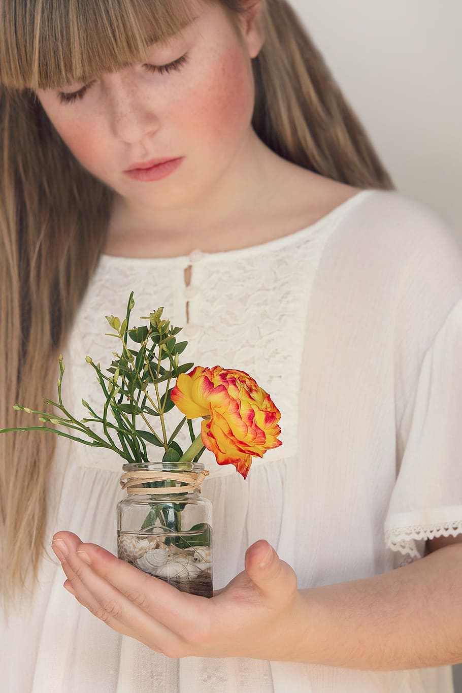 woman, holding, clear, glass jar, orange, red, ranunculus flower, flower, ranunculus, spring flower