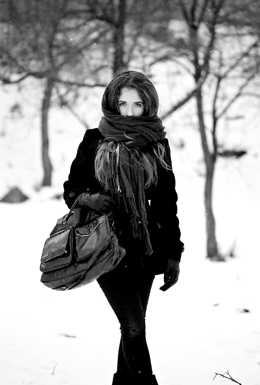 Una niña con un suéter y gafas en invierno en un bosque cubierto de nieve