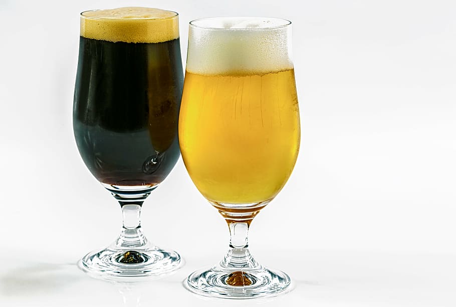 two, clear, footed drinking glasses, two types of beer, dark, caramel, wheat, a pint, beer, guiness