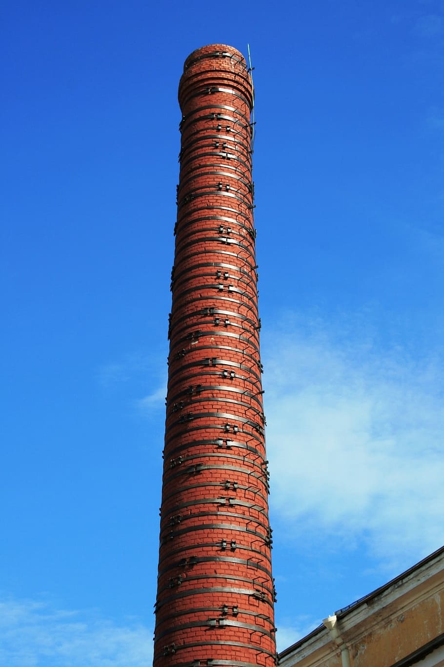 smokestack, red, brick, tall, circumventing metal ties, cylindrical, sky, blue, chimney, tower