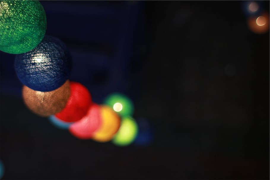 shallow, focus photography, assorted-color ornaments, lights, balls, spheres, blurry, close-up, focus on foreground, indoors