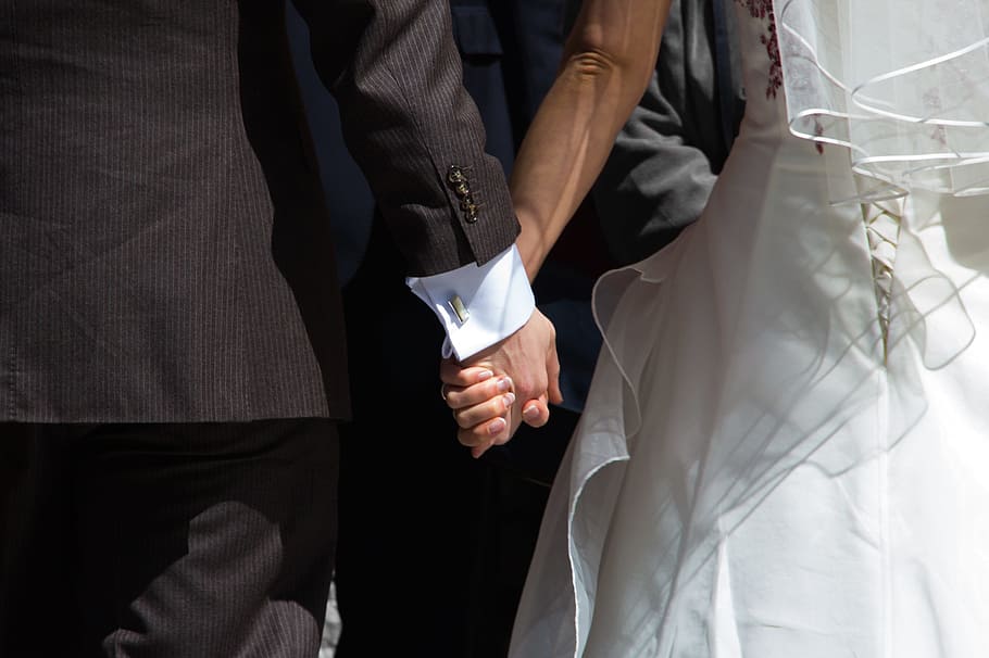 man, wearing, black, suit, woman, wedding dress, couple, clasping, hands, getting married