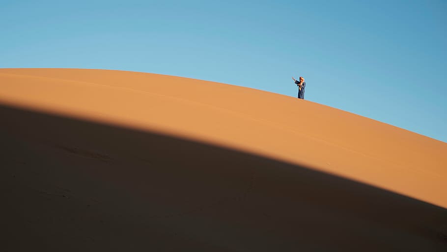 person, standing, sand, daytime, desert, landscape, sunny, highland, mountain, blue