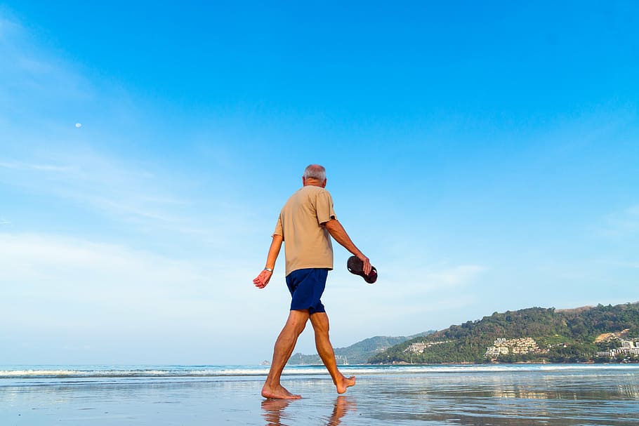 man, wearing, brown, t-shirt, blue, shorts, walking, seashore, daytime, beach