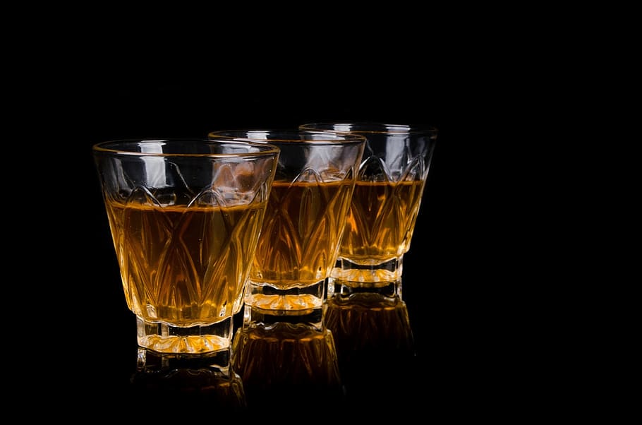 three, clear, crystal-cut rock glasses, brown, liquid, bar, liquor, barman, pouring, close-up
