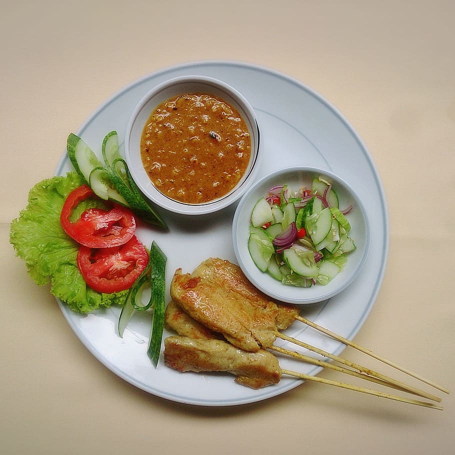 Comida tailandesa, satay, brocheta, satay de pollo, salsa para mojar, comida y bebida, comida, foto de estudio, fondo de color, placa
