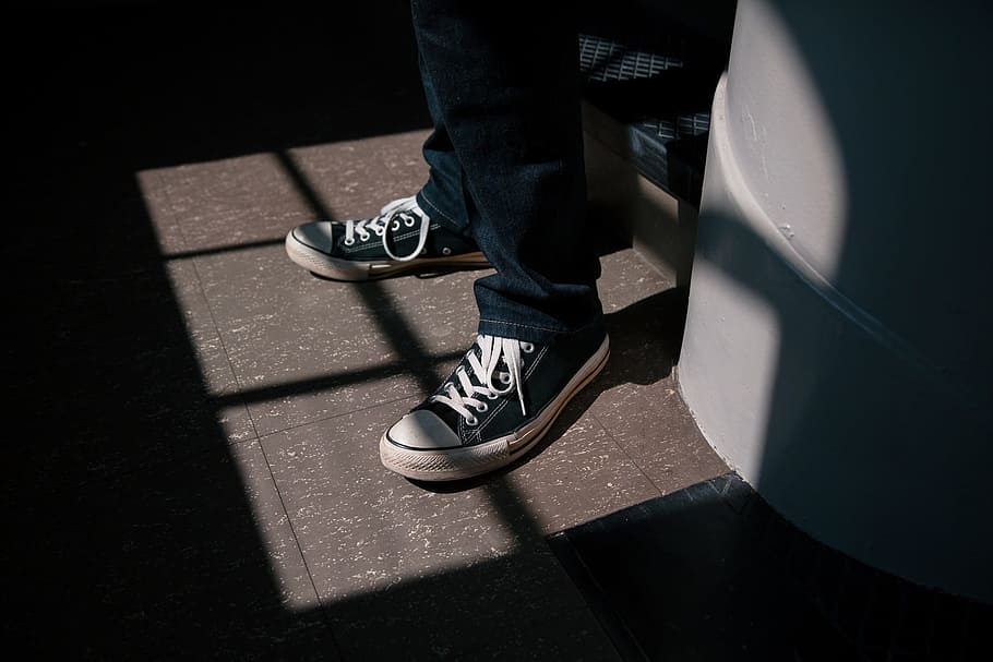 person, wearing, black-and-white, converse, all-star, sneakers, behind, white, wall, shoes