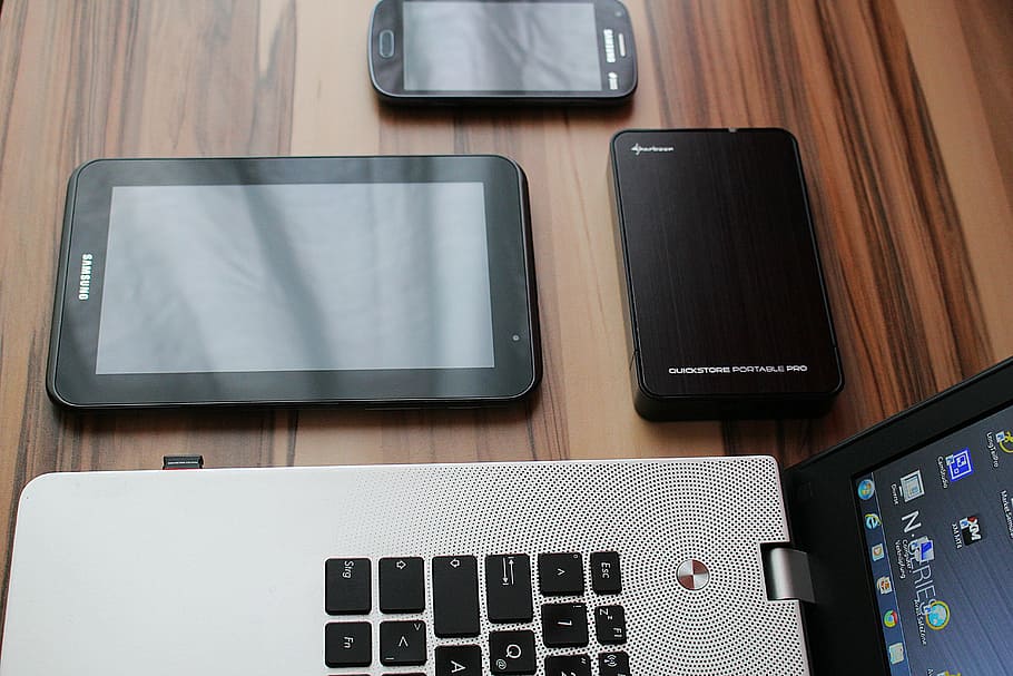 negro, teléfono inteligente Samsung con Android, tableta Samsung, banco de energía, computadora portátil gris y negra encendida, mesa, tableta, teléfono inteligente, computadora portátil, disco duro