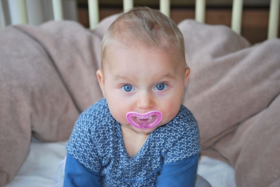 baby, pink, sitting, crib bumper, Child, Girl, People, Pacifier, blue eyes, looking at camera