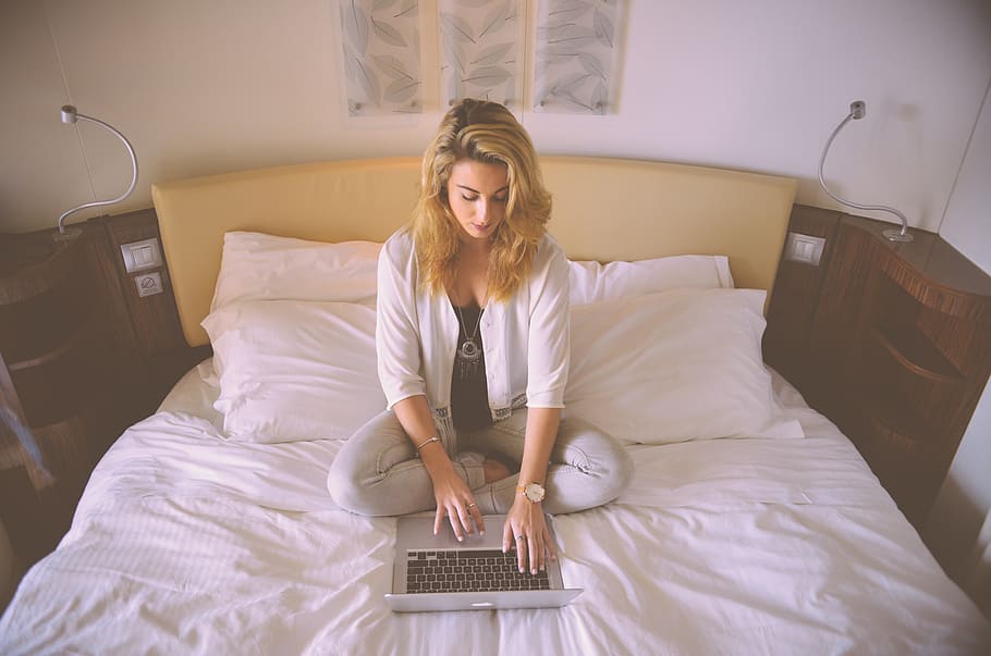 Mujer, sentado, cama, tocar, laptop, trabajando, mecanografía, mujer de negocios, persona, computadora