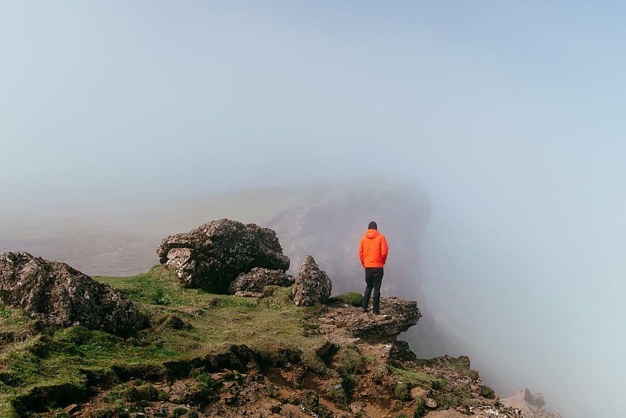 person, standing, mountain, top, daytime, wearing, orange, cliff, people, man