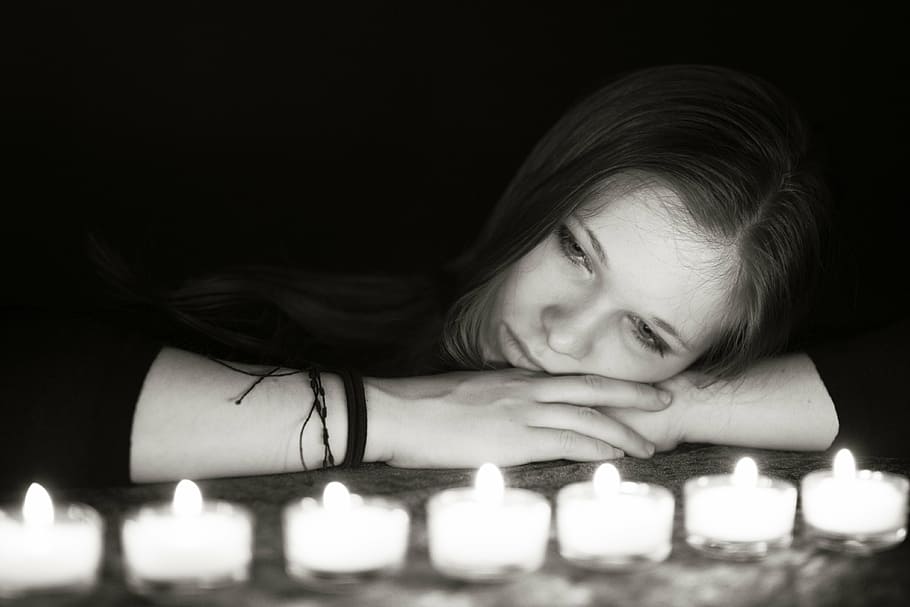 grayscale photo, woman, laying, looking, tealight candles, light, candles, dark, girl, romantic