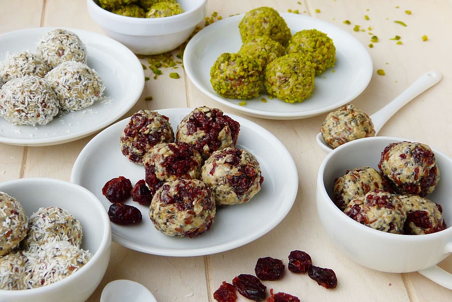 pastries, white, ceramic, plate, energy balls, cranberries, cranberry, pistachios, coconut flakes, flax seed