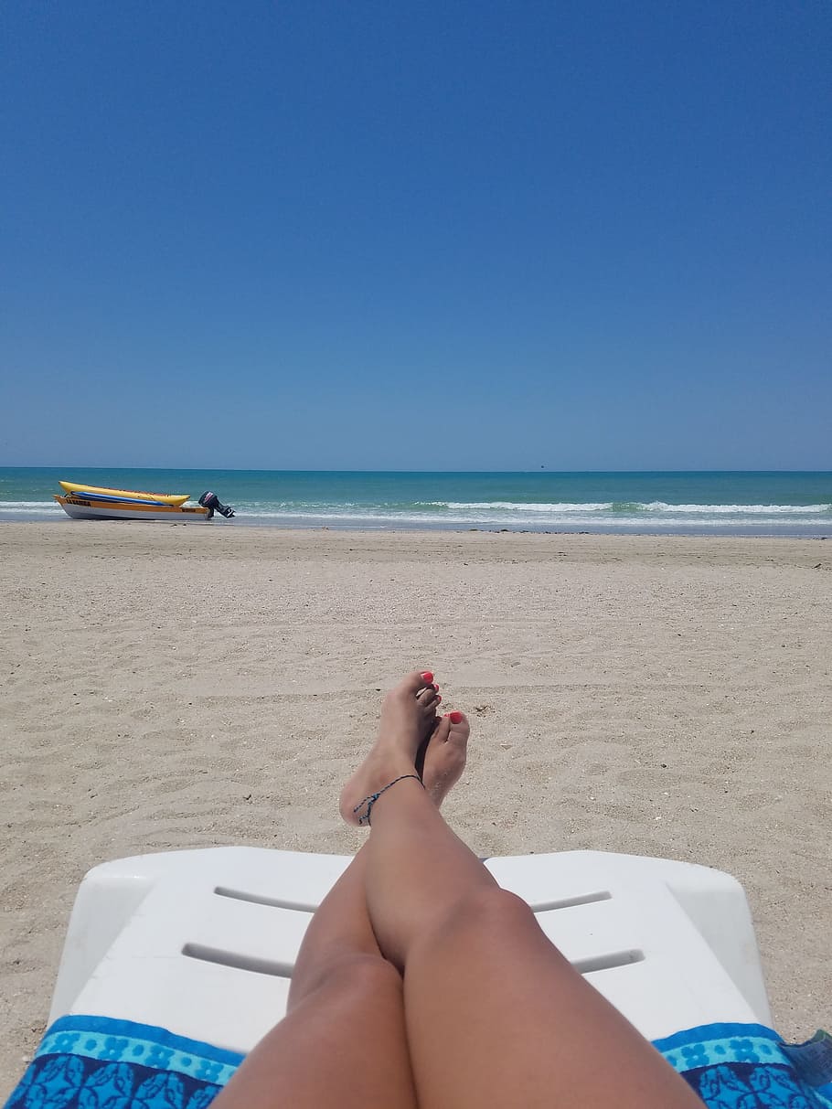 woman, laying, white, plastic sunbathing chair, beach, daytime, plastic, sunbathing, chair, feet