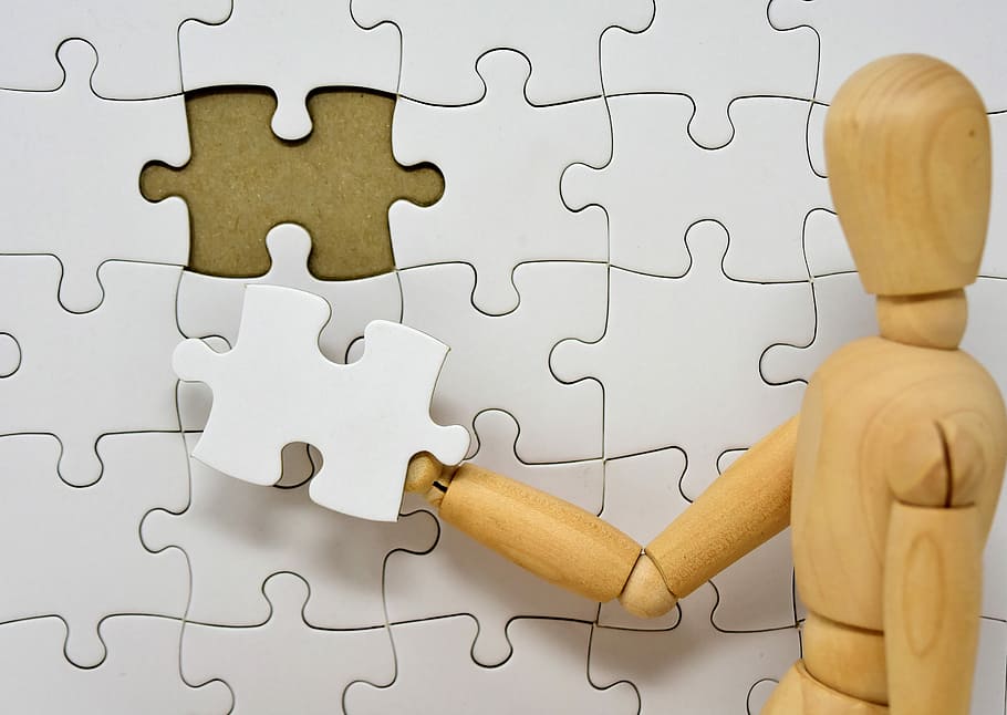 closeup, brown, wooden, dummy, holding, white, puzzle piece, figure, wood, puzzle
