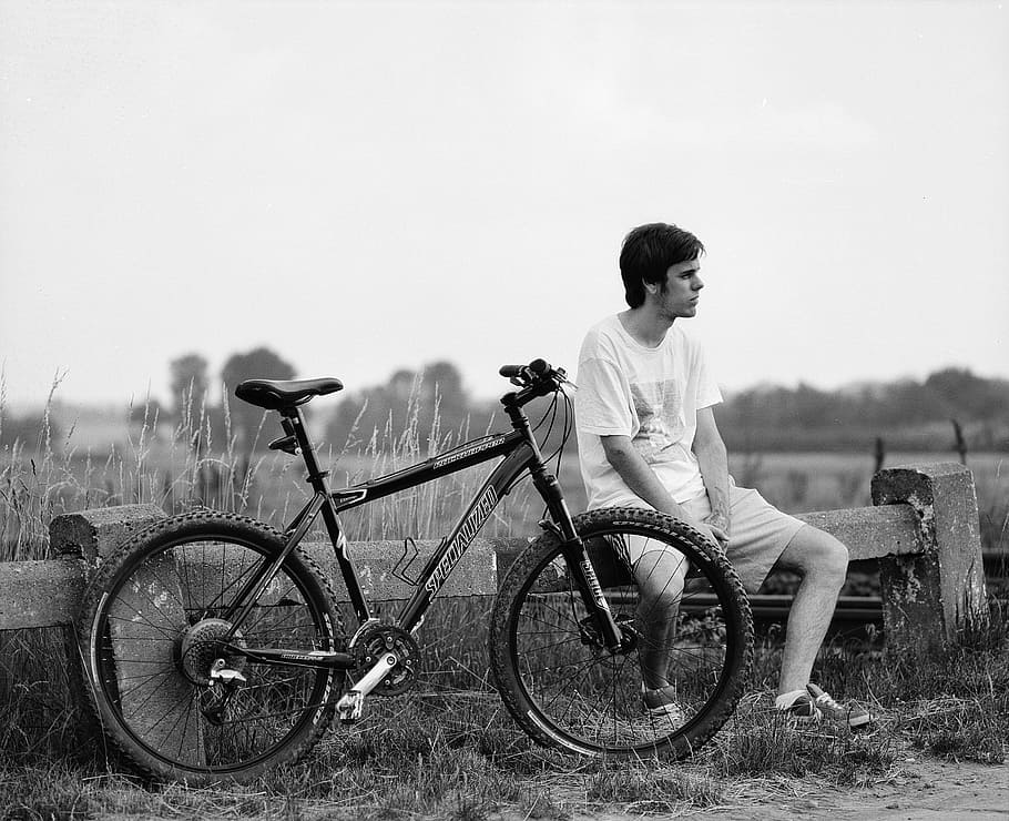 fotografi abu-abu, pria, duduk, di samping, sepeda, mencari, kiri, samping, istirahat, hitam dan putih