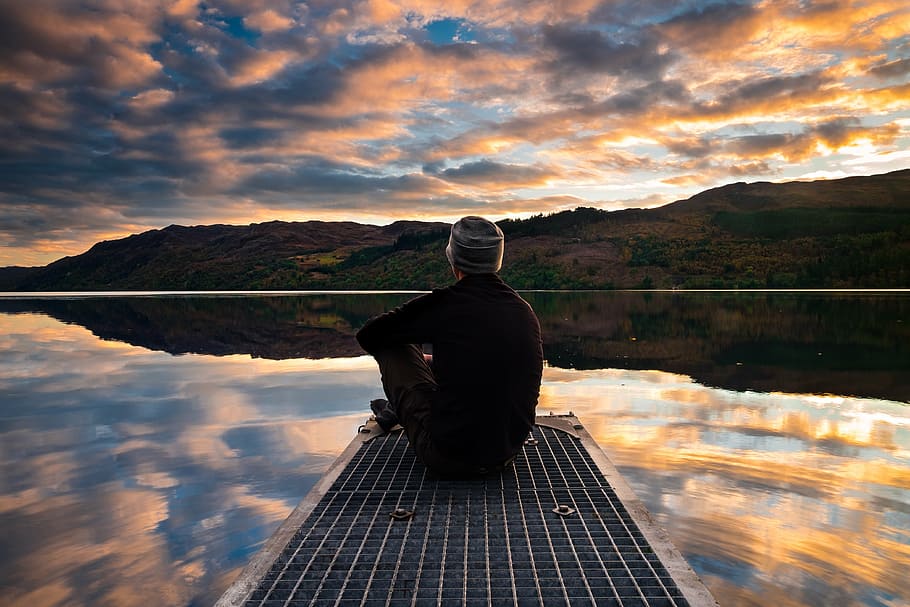 person, sitting, dock, bridge, front, green, mountain, body, water, sunset