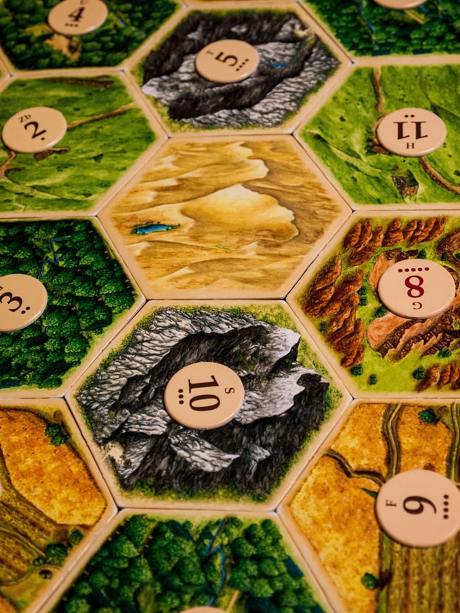 assorted-printed game board, board game, settlers of catan, game, pieces, table, numbers, hexagon, shape, competition