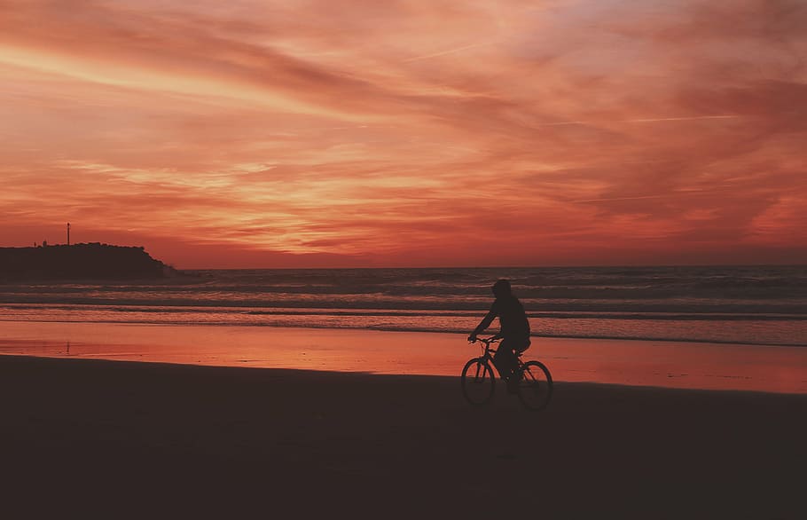 silhueta, pessoa, montando, bicicleta, viajando, praia, escuro, mar, oceano, nuvens