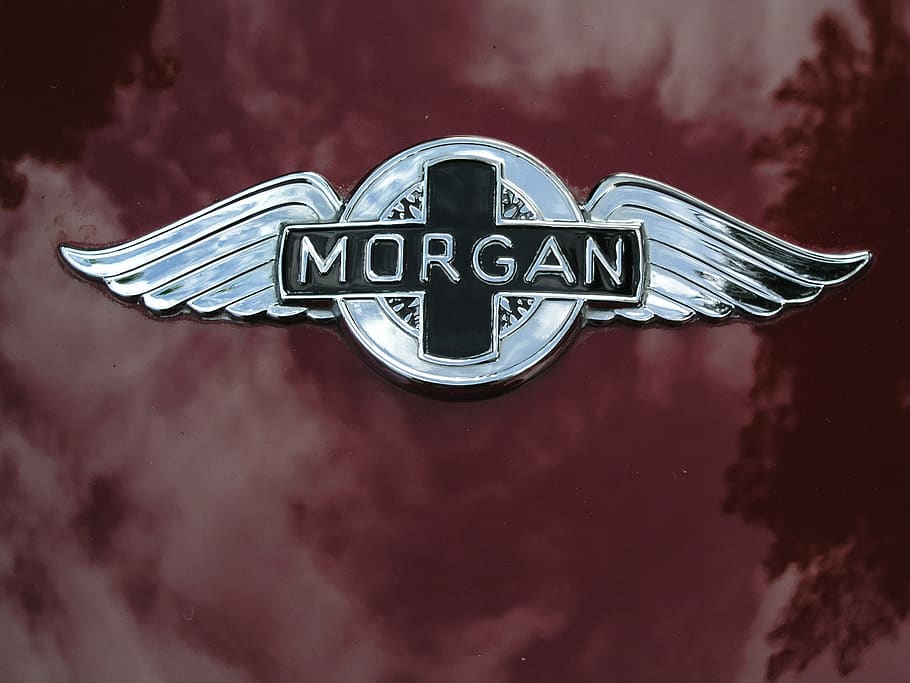 car badge, metal, emblem, morgan, communication, text, western script, sign, night, single word