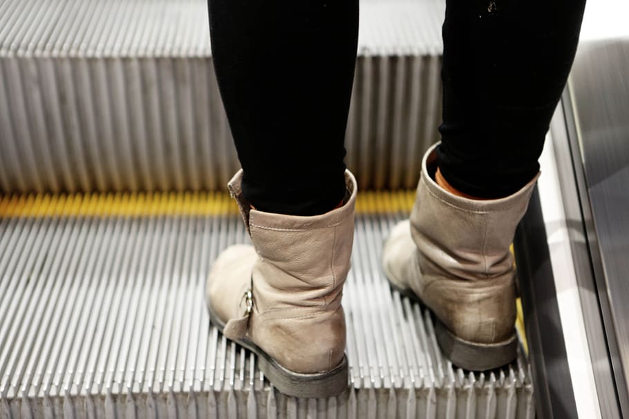 boots, pants, escalator, subway, human leg, low section, body part, shoe, human body part, one person