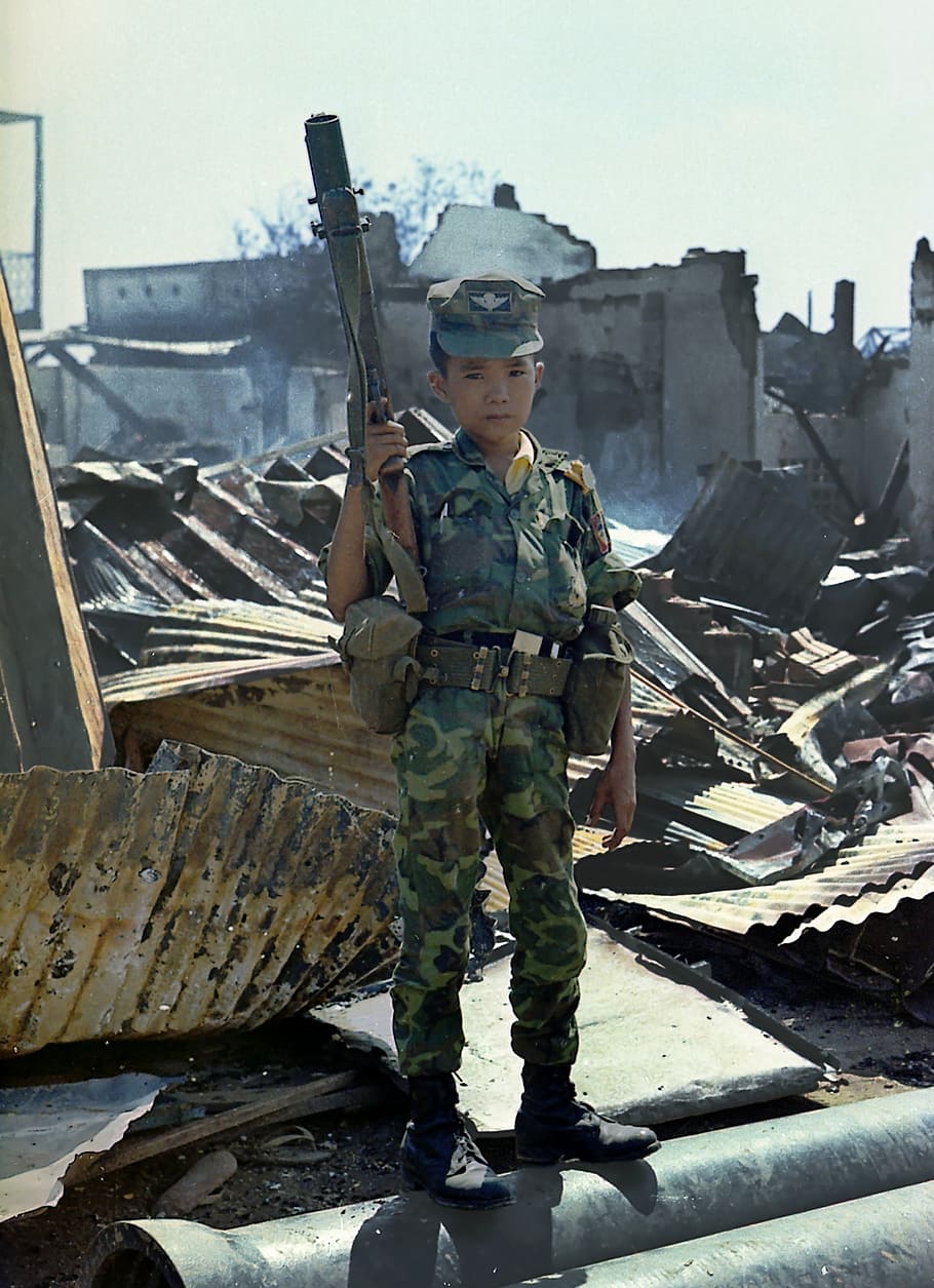 garoto segurando arma, criança pequena, triste, soldado, guerra, vietnamita, 1968, criança vietnamita, sem filhos, 12 anos