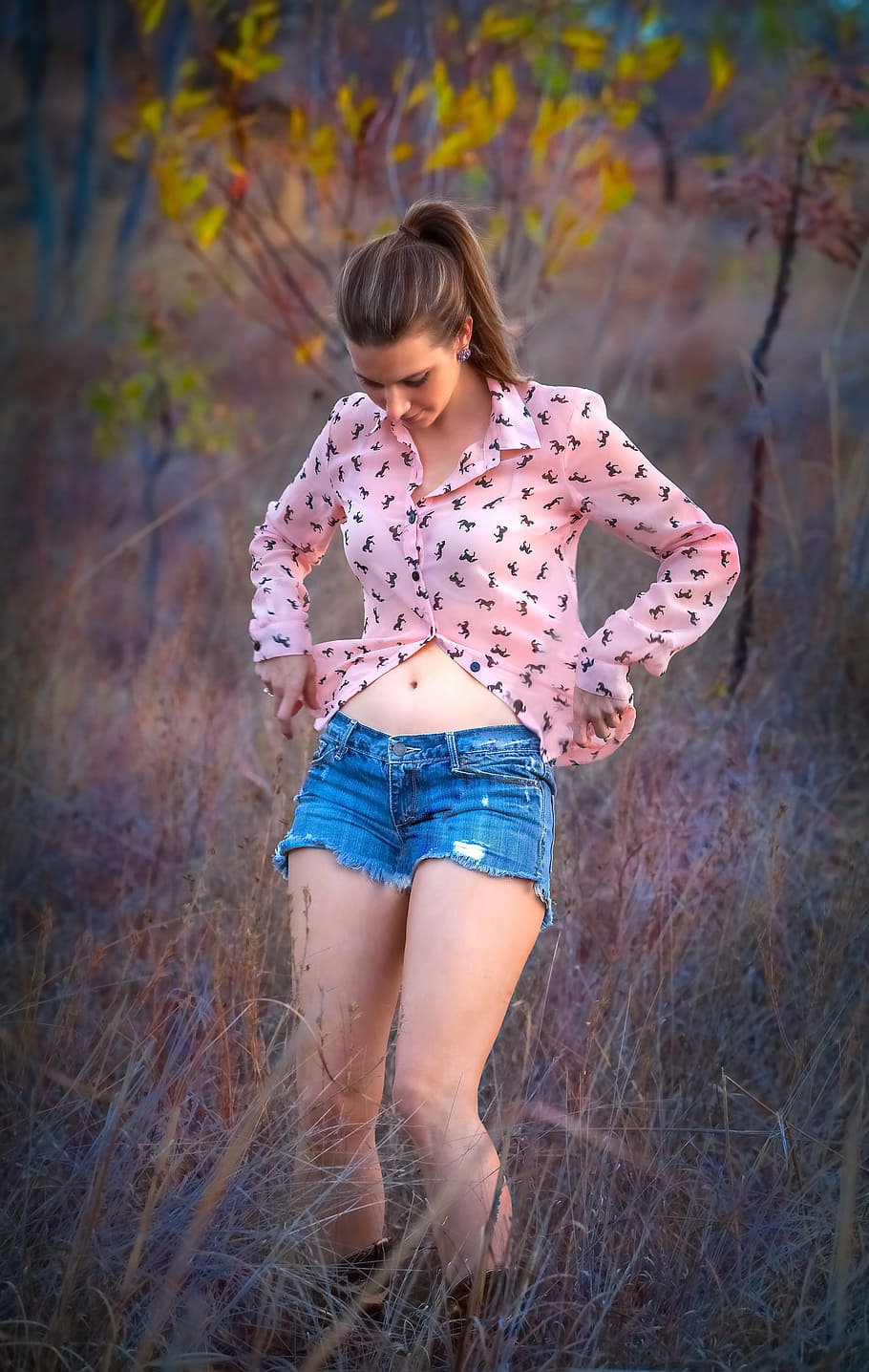 woman, wearing, pink, dress shirt, blue, denim, cut-off, shorts, standing, grass