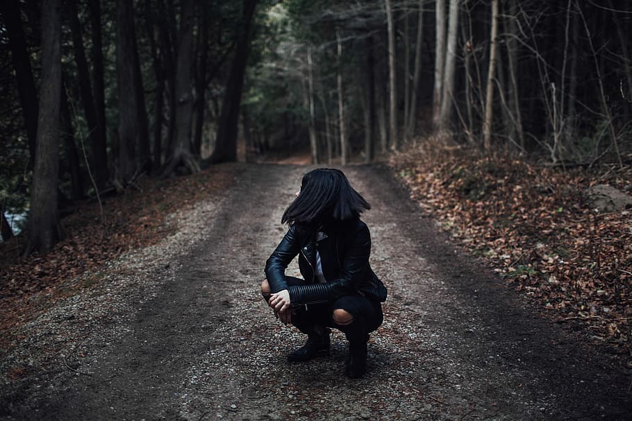 woman, black, leather jacket siting, dirt road, trees, daytime, woman in black, black leather jacket, road between, people