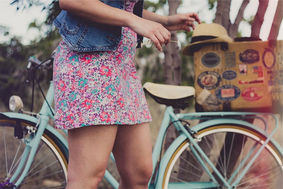 Mujer, de pie, al lado, bicicleta de crucero, rosa, floral, vestido, niña, vestido de verano, denim
