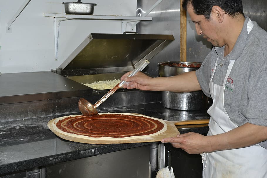 homem, colocando, molho, massa de pizza, pizza, fazendo pizza, cara de pizza, pizzeiro, loja de pizza, pizza saouce