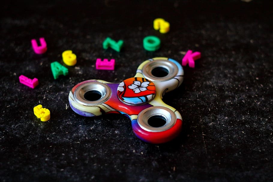 spinner, game, letters, background, floral pattern, petals, toy, multi colored, close-up, still life