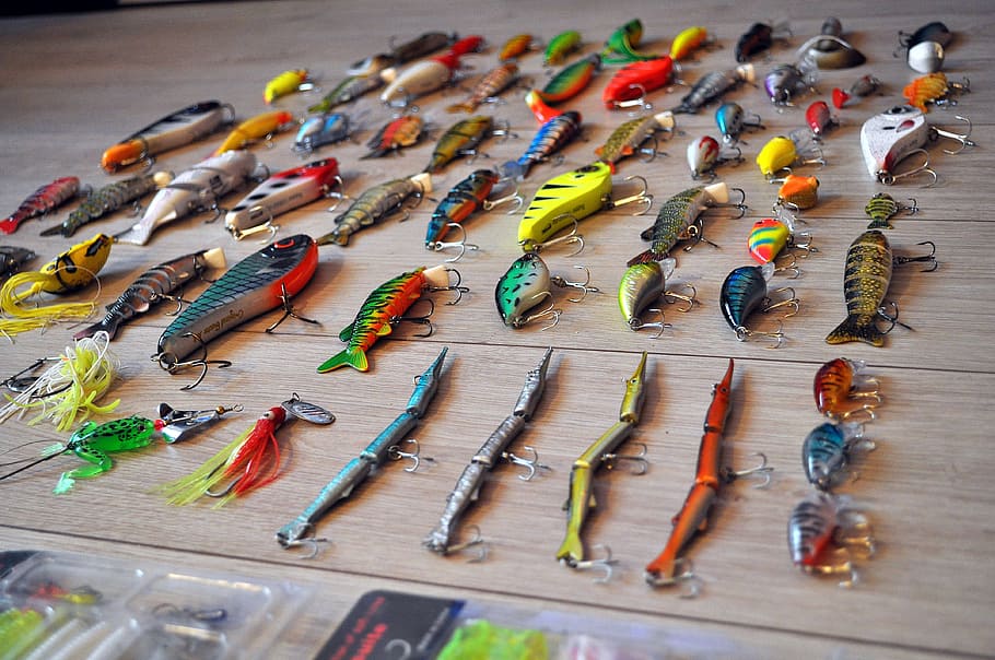 close-up photo, assorted-color fish, lure, lot, brown, wooden, surface, fishing, rod, hooks