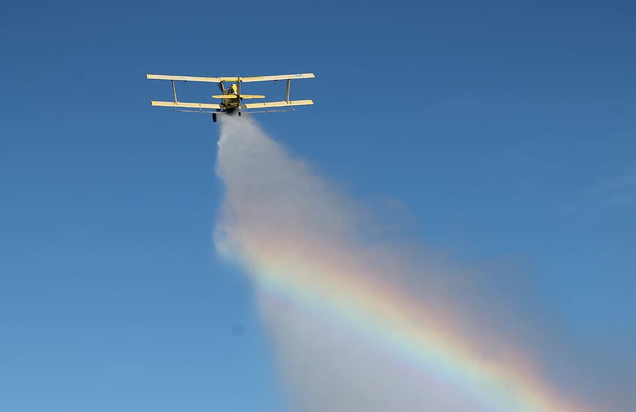 eg cat, crop duster, dumping water, rainbow, air vehicle, transportation, mode of transportation, sky, airplane, low angle view