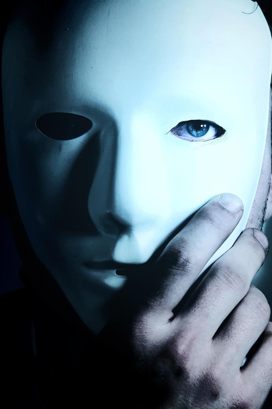 person, wearing, white, mask, man, blue eyes, hand, mystery, human body part, portrait