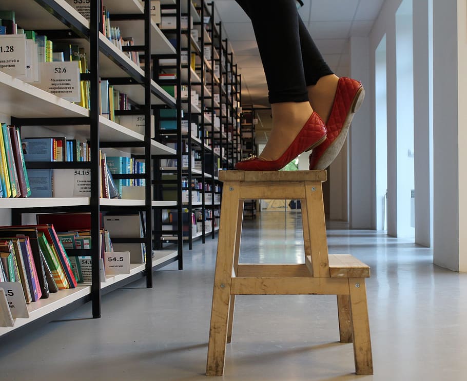 person, red, shoes, standing, wooden, step ladder, inside, library, stool, stand