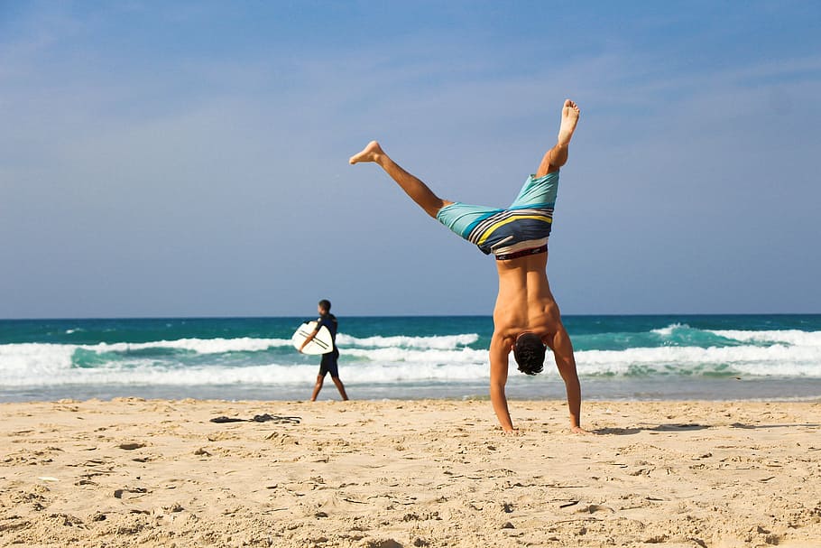 man, standing, using, hand, seashore, daytime, handstand, beach, sea, ocean