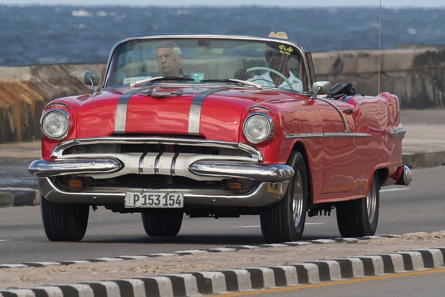 two, men, riding, classic, red, convertible, coupe, daytime, cuba, havana