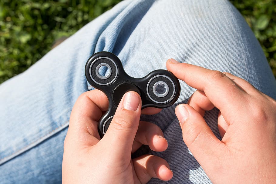 person, holding, black, hand spinner, fidget spinner, spinner, toys, with your index finger to turn on, in hand, between the finger hold